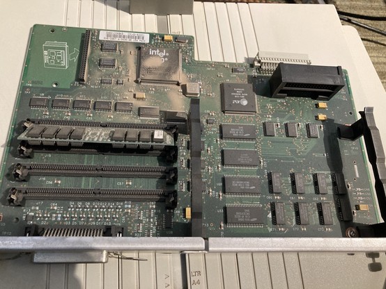 A motherboard for an HP laserjet 4v. It has an Intel i960 CPU and an 8mb ram simm installed. The cpu is caked with 30 year old dust. 